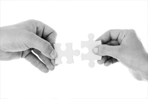 Zwart wit foto met twee handen met puzzelstukjes